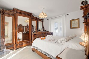 A bedroom with a large bed, wooden furniture, and a mirror. - Ornavasso Apartments (Ornavasso)