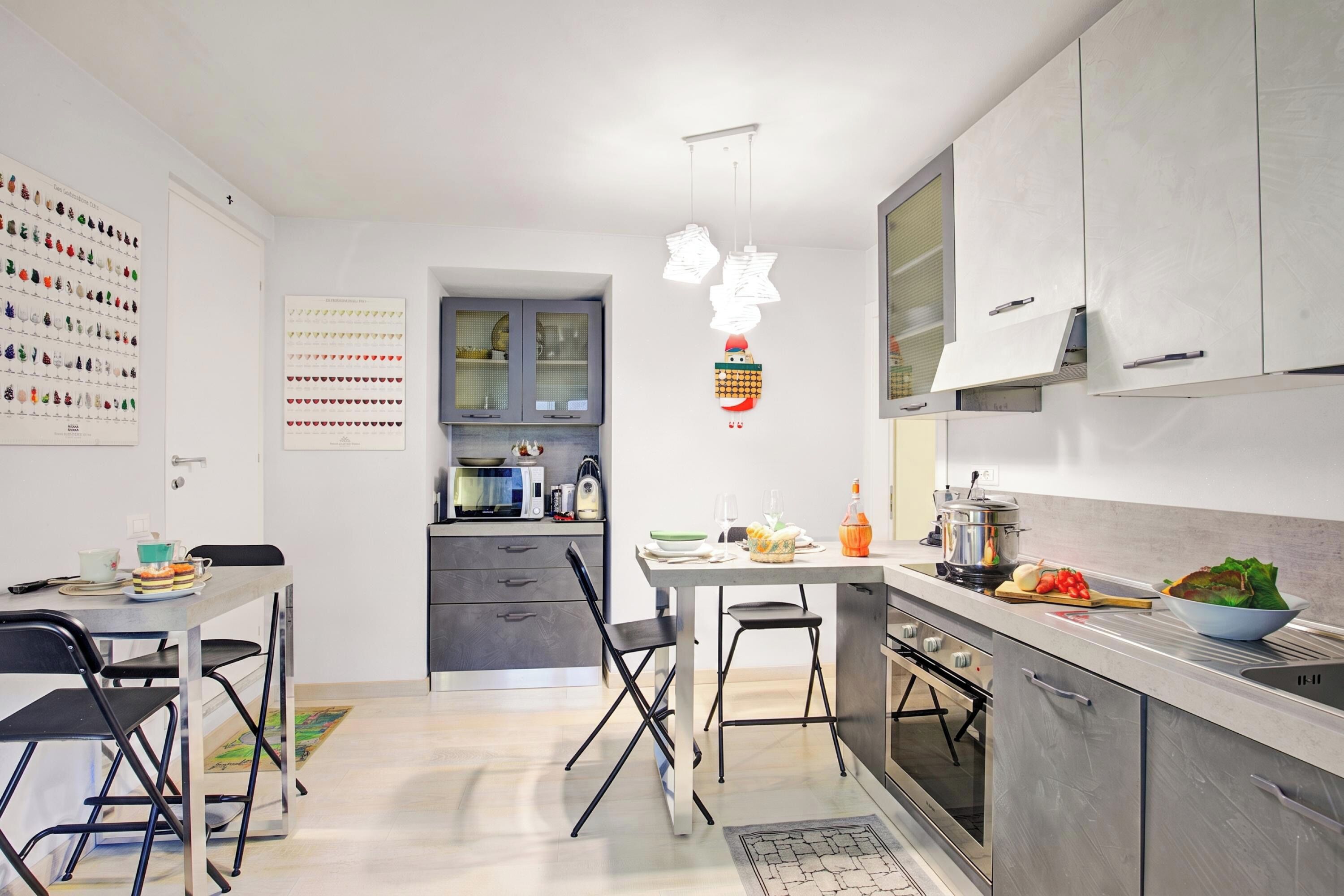 Et moderne køkken med spiseplads, der har en hvid bordplade, rustfrie stålemmer og et spisebord med stole.