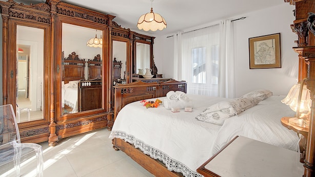 Un dormitorio con una cama grande, muebles de madera y un espejo.