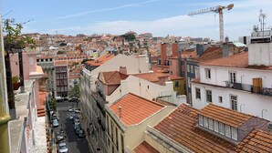 Un paysage urbain présentant une variété de bâtiments, dont une grande grue visible au loin, ce qui laisse supposer que des travaux de construction ou d’aménagement sont en cours.