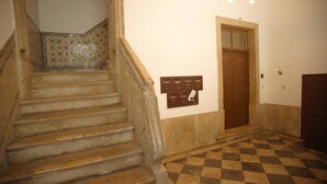Eine Treppe mit Schachbrettmuster führt zu einer Tür.