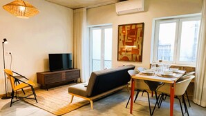 Un salon moderne avec un canapé, une table à manger et un téléviseur.