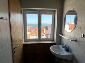 A bathroom with a window, a sink, and a mirror.
