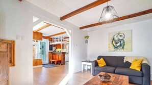 Een ruime woonkamer met een grijze bank, houten vloeren en een houten salontafel.