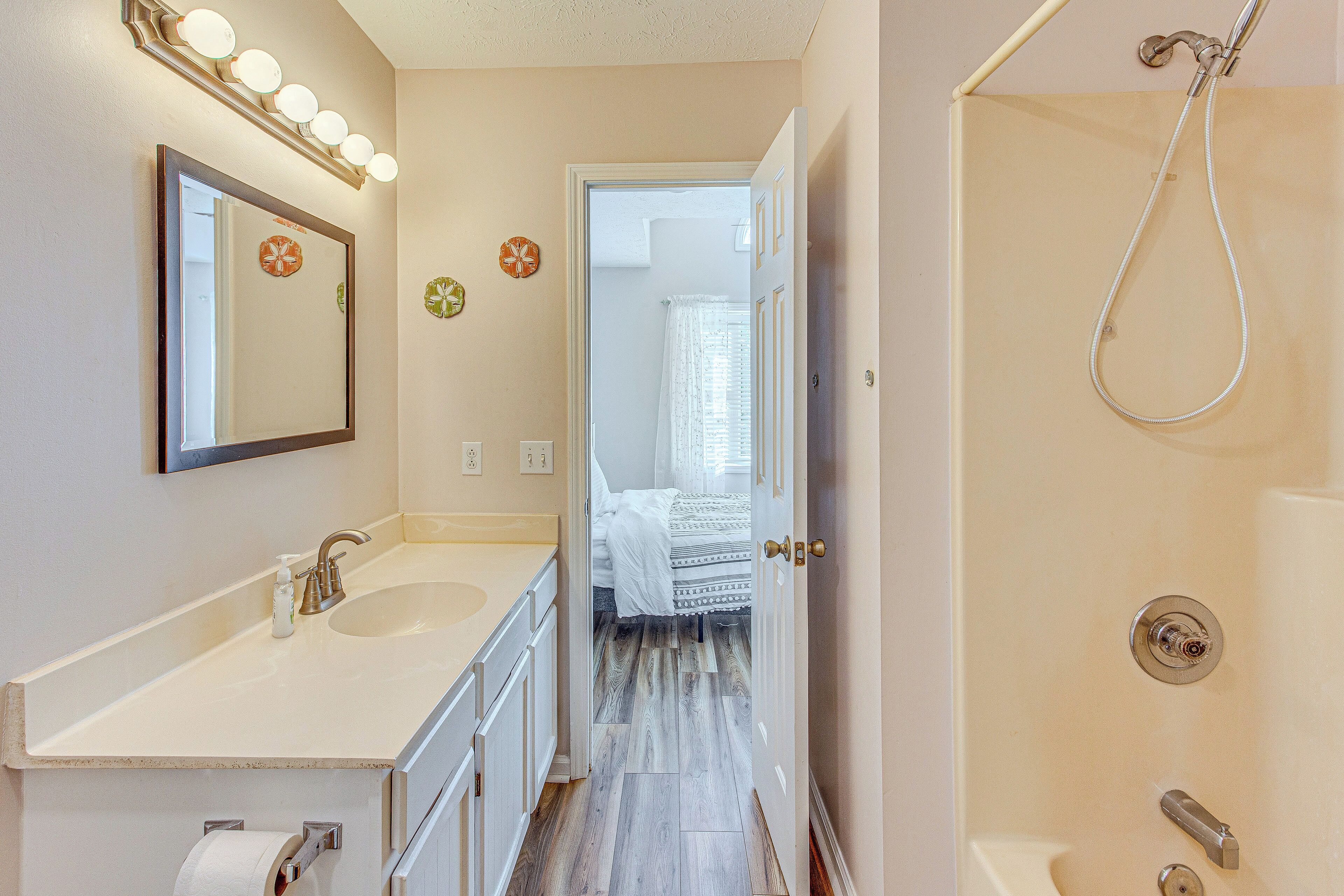 Une salle de bain avec un lavabo, un miroir et une douche.