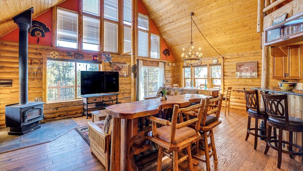 A log cabin interior with a wooden dining area, a fireplace, and a television. - 4 Mi to Fossil Beds: Private Log Cabin on 3 Acres (Florissant)