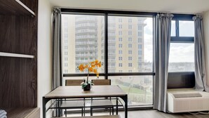 Et moderne værelse med et stort vindue, et spisebord med en blomstervase og en indbygget aircondition.