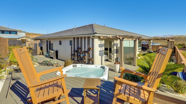 A hot tub on a wooden deck with two wooden chairs, a covered patio area, and a view of a mountainous landscape. - 22 Mi to Zion: Mtn-view 'oasis Sanctuary' (Hurricane)