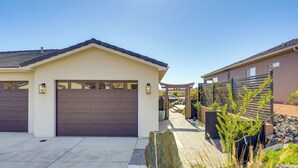 A modern residential building with a garage, a paved driveway, and a landscaped garden area with rocks and plants. - 22 Mi to Zion: Mtn-view 'oasis Sanctuary' (Hurricane)