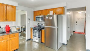 A kitchen with wooden cabinets, stainless steel appliances, and a red toaster. - 4 Mi to Dtwn: Family Home in Buffalo (Buffalo)