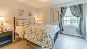 A bedroom with a bed, bedside lamps, a nightstand, a window with curtains, and wall art. - 4 Mi to Dtwn: Family Home in Buffalo (Buffalo)