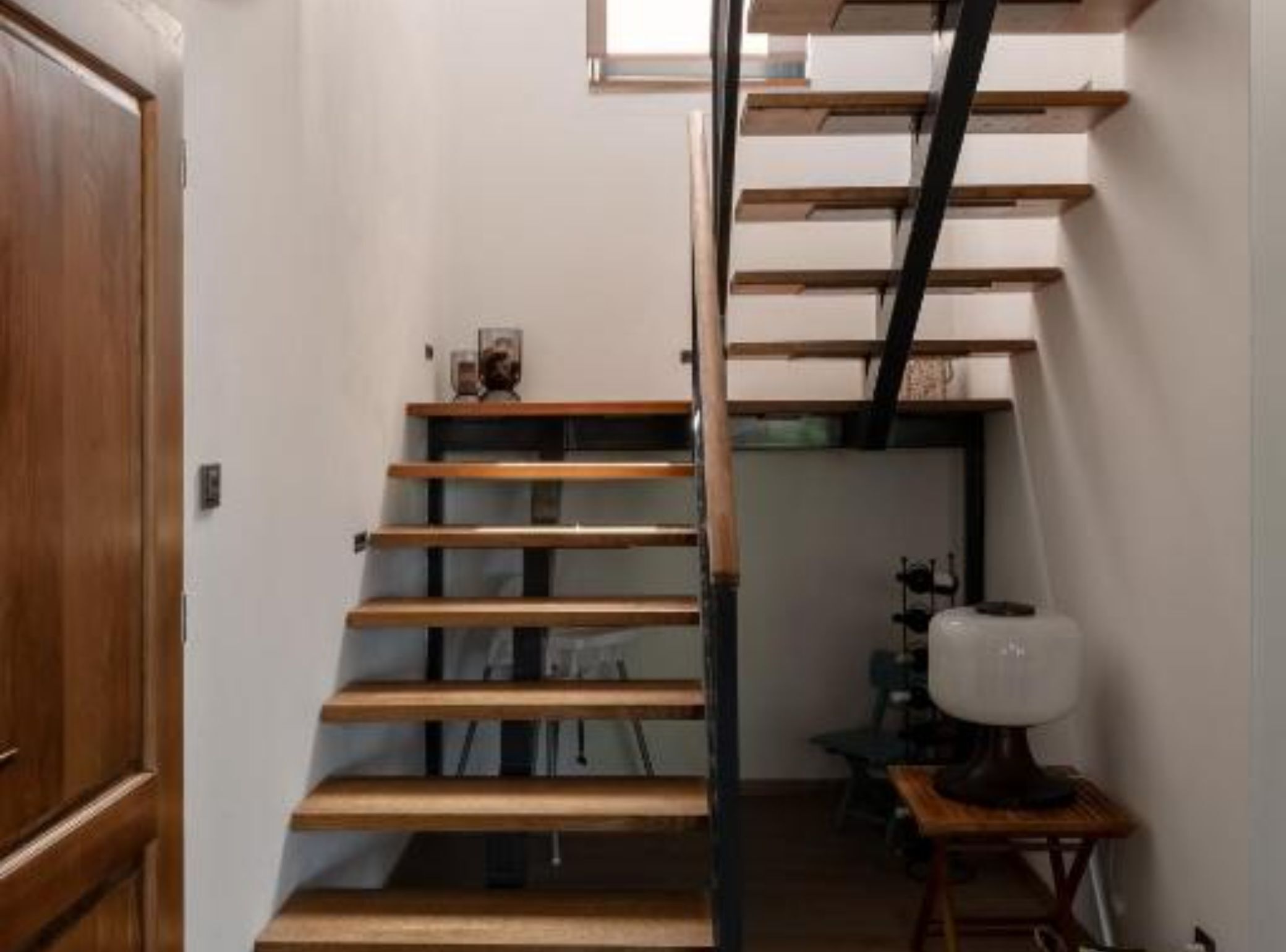 Un escalier avec des marches en bois et une rampe en métal.