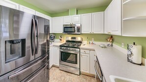 A kitchen with white cabinets, stainless steel appliances, and a green wall. - 8 Mi to Bonners Ferry: Quiet Getaway w/ Patio (Moyie Springs)