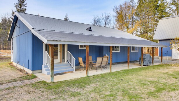 A blue building with a covered porch, a staircase, and outdoor seating. - 8 Mi to Bonners Ferry: Quiet Getaway w/ Patio (Moyie Springs)