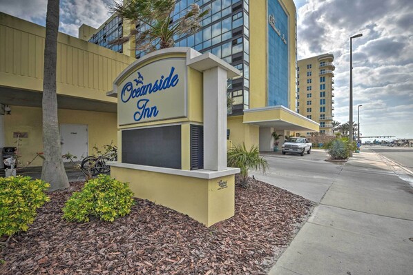 Das Außere des Oceanside Inn Hotels mit deutlicher Beschilderung, einem Parkplatz und einem Gebäude mit Balkonen.