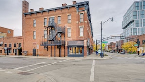 A street view with a brick building featuring a fire escape, a storefront labeled 'Lighthouse,' and a modern building in the background. - Parking, Walk to Convention Center, Secured Entry (Columbus)