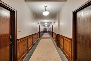 A hallway with wooden doors, a carpeted floor, and a ceiling light. - Parking, Walk to Convention Center, Secured Entry (Columbus)