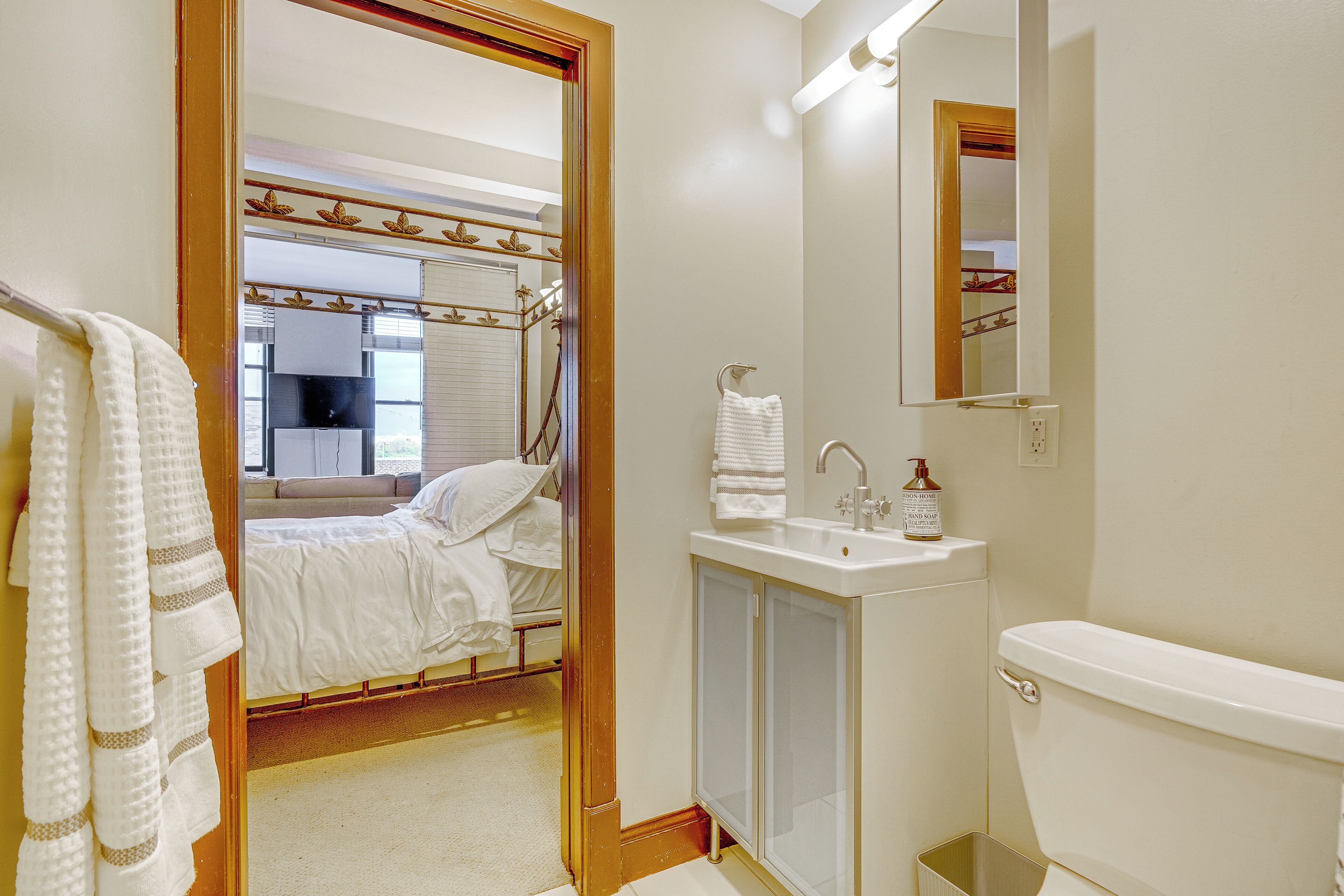 Une salle de bain d’hôtel équipée d’un lit, d’un lavabo et de toilettes.