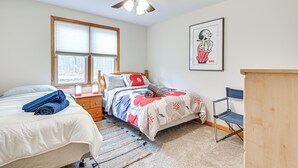 Une chambre à coucher comprenant un lit, une chaise, un bureau, un ventilateur de plafond et une fenêtre.