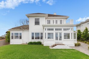Stunning two-story home with a classic facade, spacious backyard, and entrance.