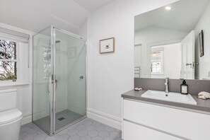 Enjoy a sleek, contemporary bathroom with a glass-enclosed shower, large vanity, and sink.