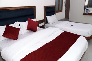 A hotel room with two beds, each with white bedding and red pillows. - Hotel Gush  New Delhi Railway Station (New Delhi)