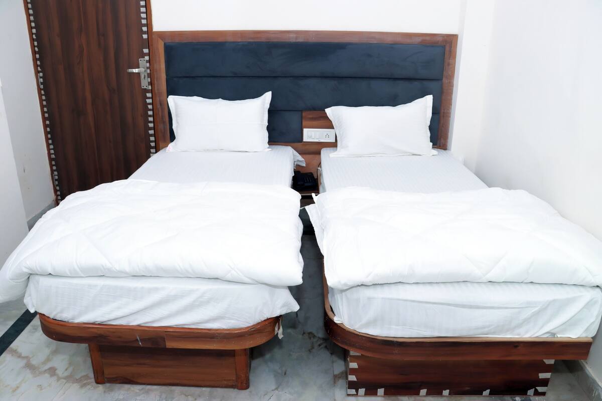 A double bed with a wooden frame and white bedding.