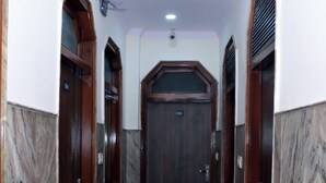 Un pasillo con piso de mármol, puertas de madera y un ventilador de techo.
