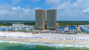 Un hotel costero con varios edificios altos, una playa y una zona de piscina.