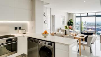 Een moderne keuken met inbouwapparatuur, een eetgedeelte met uitzicht en een groot raam.