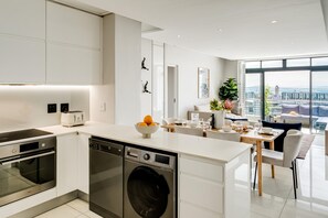 Una cocina moderna con electrodomésticos integrados, un comedor con vistas y un amplio ventanal.