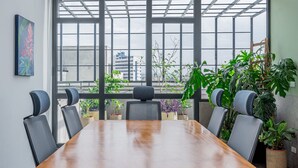 A conference room with a large table and six chairs, large windows with a view of buildings, and several potted plants. - w Comfy 1BR w Perfect Balcony in Casco View (Panama City)