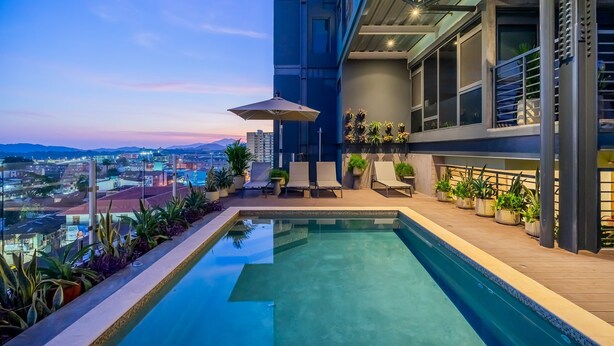 A rooftop pool with lounge chairs and potted plants, overlooking a cityscape. - w Comfy 1BR w Perfect Balcony in Casco View (Panama City)