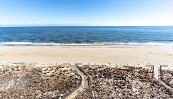 A beach with a sandy shore and a clear view of the ocean. - Marigot Beach-Beautiful 3 Bedroom Direct Oceanfront Condo! (Ocean City)