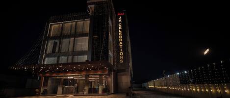 Un hotel con fachada moderna, amplias ventanas y un cartel llamativo que dice "Hotel JKCELEBRATIONS".