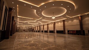 A spacious, well-lit hotel lobby with a polished marble floor, elegant ceiling design, and a chandelier. - Hotel J.K. Celebration (Jabalpur)
