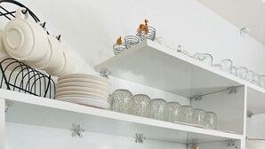 A kitchen with a coffee maker, a glass carafe, and a coffee grinder on the counter. - ŞİRİN APARTROOMS (Denizli)