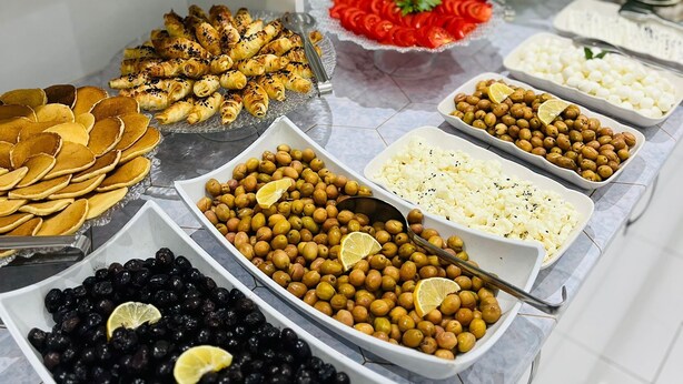 A buffet with various dishes including olives, black beans, and a salad. - ŞİRİN APARTROOMS (Denizli)