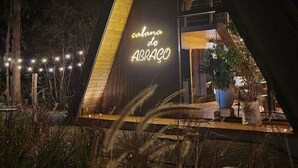 Een modern gebouw met een neonbord waarop 'calama do ABRAÇO' staat, 's nachts.