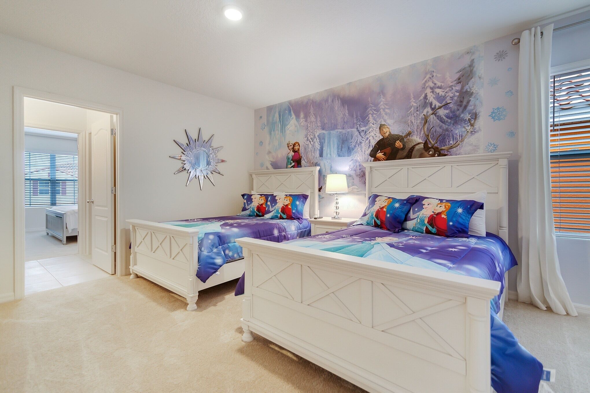 A bedroom with two beds, a mural, and a white dresser.