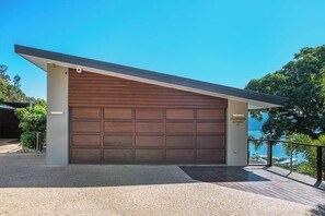 A modern garage with a large door, a sloped roof, and a view of the sea.