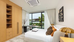 Ein modernes Schlafzimmer mit einem großen Bett, einem Schreibtisch und Blick auf ein Gebäude durch große Fenster.