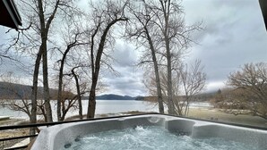 Uma banheira de hidromassagem com vista para um lago e montanhas.
