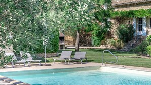 A swimming pool with lounge chairs and a stone building in the background. - les Marcellines, character property with heated swimming pool and views (Saint-Restitut)