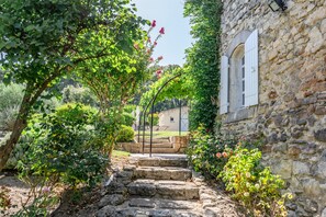 Un vialetto in pietra conduce a un edificio rustico con una finestra e una porta.