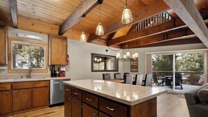 A spacious kitchen with wooden cabinets, a large island, and pendant lighting. - Chambers Dreamin'-Chambers Beach, Pool & Tennis, Beautiful 3 bedroom, 2 bath (Homewood)