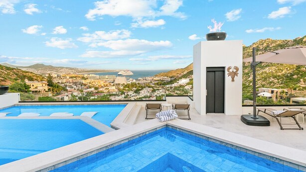 A rooftop infinity pool with a view of a coastal city, lounge chairs, and a modern architectural design. - New Pool+Spa+Games+Large BBQ+Designer+Beautiful (Coachella)