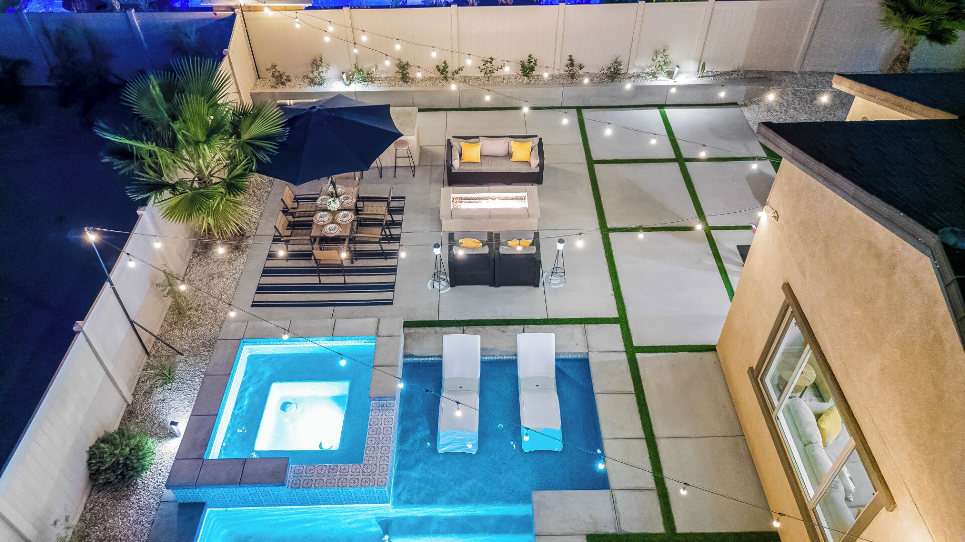 A rooftop pool area with a hot tub, lounge chairs, and a dining set.