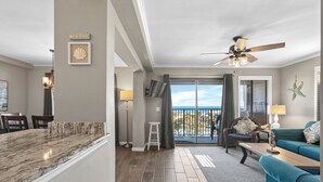 A modern living room with a large window, a ceiling fan, and a view of the ocean. - A421 at Myrtle Beach Resort (Myrtle Beach)