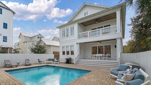 Ein zweistöckiges Haus mit Pool, Außenbereich und überdachter Terrasse.